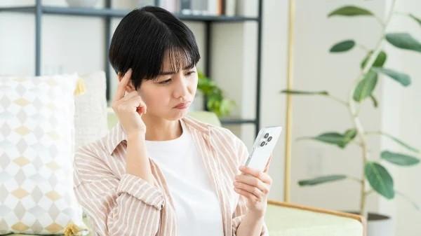 女子看着手机思考 (图片来源:翻拍)