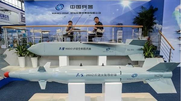 2012年11月12日，在珠海第九届中国国际航空航天博览会开幕前夕，几名男子坐在中国北方工业集团有限公司（中国兵器工业集团）的导弹模型展台旁。（图片来源：PHILIPPE LOPEZ/AFP via Getty Images）