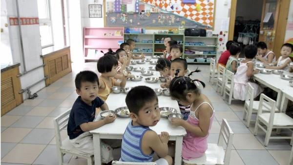 2004年8月5日,学生们在北京的一家幼儿园里享用早餐。(图片来源:GOH Chai Hin/AFP via Getty Images)