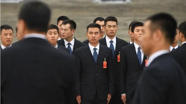 2017年10月25日,在中共中央政治局常务委员会成员名单公布后,身着西装的中共军方人员在北京人民大会堂外等候。(图片来源:GREG BAKER/AFP via Getty Images)