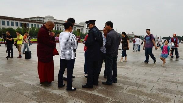 2013年6月22日，中共警察在北京天安门广场对藏族游客进行身份核查。（图片来源：MARK RALSTONAFP via Getty Images）