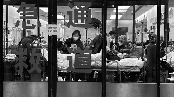 2023年1月14日,上海疫情期间,病人和护理人员站在医院急诊室封闭入口处,急诊室被用作溢流区。示意图(图片来源:Kevin FrayerGetty Images)