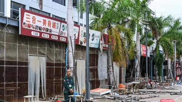 2026年9月22日,一名柬埔寨警官站在柬埔寨干丹省一家已被关闭的网络诈骗中心园区建筑外。该建筑有写着中文标牌“云尚酒店”。(图片来源:TANG CHHIN SOTHY/AFP via Getty Images)