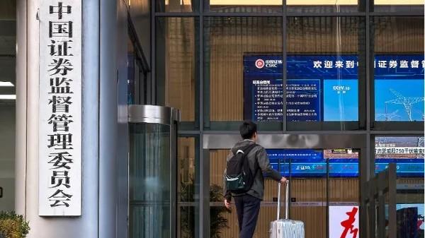 2025年11月12日,一名手提行李箱的男士走进位于北京的中国证券监督管理委员会(证监会)大楼。(图片来源:Cheng Xin/Getty Images)