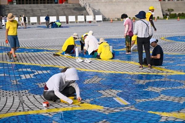 排字活动前两天,法轮功学员到广场丈量、布置画面。